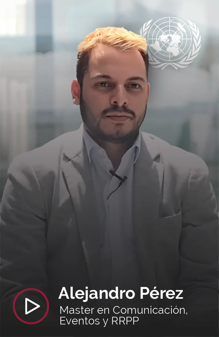 Alejandro Pérez, estudiante del Master en Comunicación, Eventos y RRPP, en una entrevista para Esden Business School. Alejandro viste una chaqueta gris y una camisa blanca mientras responde frente a la cámara. Su expresión es seria y profesional. En la parte superior derecha se puede ver el logotipo de las Naciones Unidas (ONU), lo que podría indicar su relación profesional con dicha organización. Al fondo, se aprecia un entorno corporativo moderno, con paredes de vidrio que sugieren un ambiente de trabajo contemporáneo.