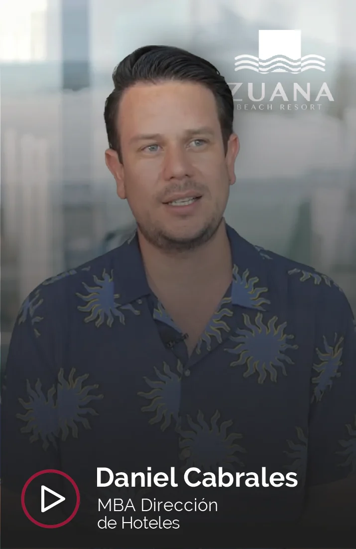 Daniel Cabrales, profesional del sector hotelero, aparece en la imagen durante una entrevista como graduado del MBA en Dirección de Hoteles. Viste una camisa con estampado tropical de tonos azules y verdes, en sintonía con su lugar de trabajo, el Zuana Beach Resort, cuyo logo se ve en la esquina superior derecha. Daniel mira hacia un lado mientras habla, reflejando su experiencia en la industria hotelera y su rol en la gestión hotelera.