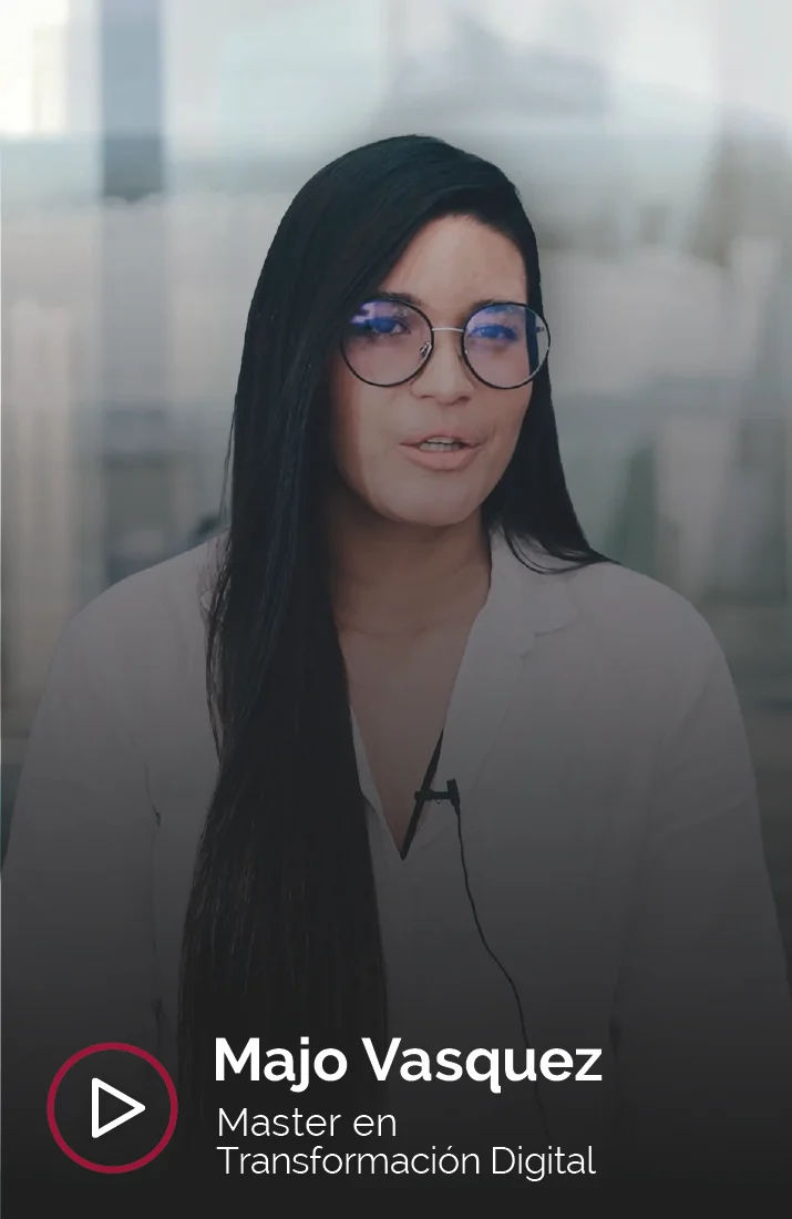 Majo Vasquez, alumna del Master en Transformación Digital, hablando frente a la cámara en un entorno moderno y profesional, con gafas grandes y cabello largo y oscuro, representando su experiencia en el ámbito de la transformación digital."